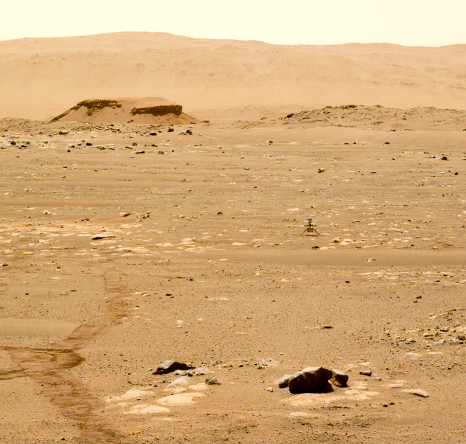Ingenuity helicopter seen from the Van Zyl overlook. Behind her is the large rock formation “Kodiak”, a delta remnant located in the next valley. NASA/JPL, sol 49, 2021.