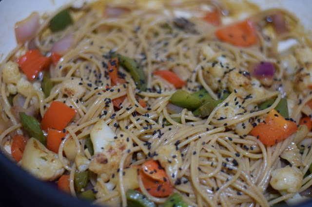 Black Sesame seeds added to the Vegan King Pao Cauliflower in the pan.  