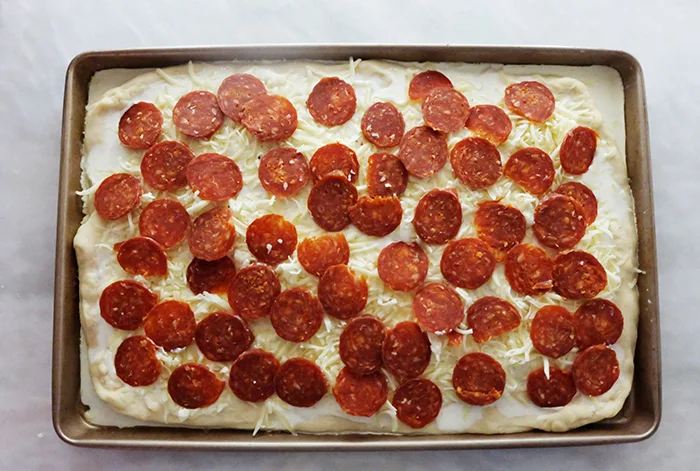white pizza topped with mozzarella and pepperoni ready to bake