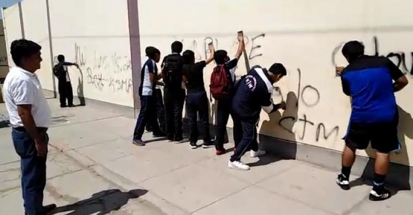 EJEMPLAR: Escolares ensucian pared de colegio y director los obliga a limpiarlas como correctivo