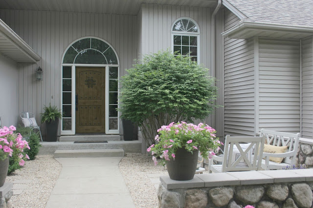 Pretty pea gravel courtyard and knotty alder front door - Hello Lovely Studio