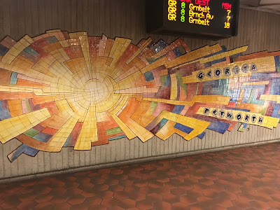 A colorful cracked tile piece of art that looks a little like a sunburst.