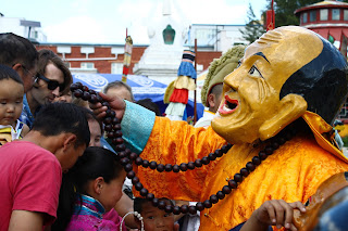 Olvasójával áldást osztó buddhista szerzetes az ulánbátori Cam táncon, a Dashchoilin kolostor udvarán.