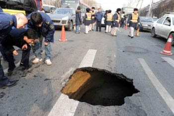 China Sinkholes on Chinese Workers Inspect A Sinkhole In A Street In Beijing On Feb 8