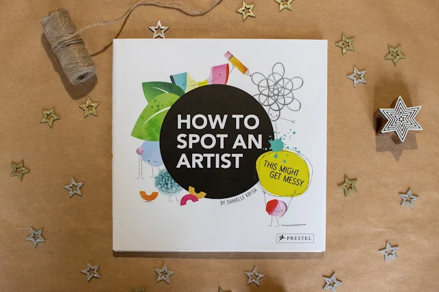 A square hardback book with the title "How To Spot An Artist" ready to be wrapped as a christmas present for a 5 year old