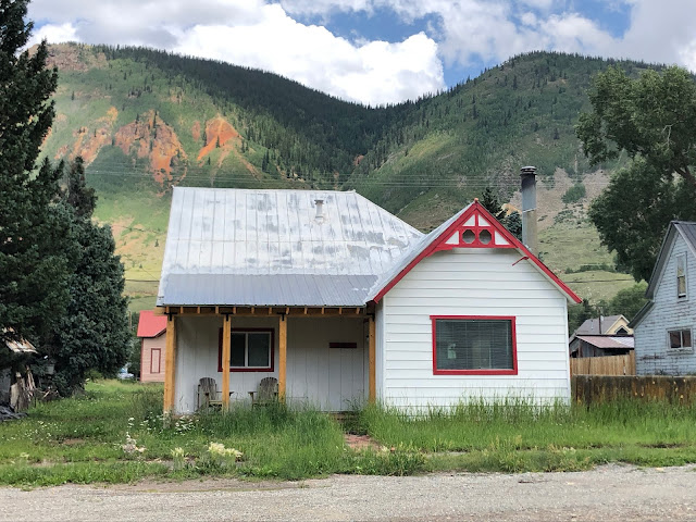 small home with mountain behind it