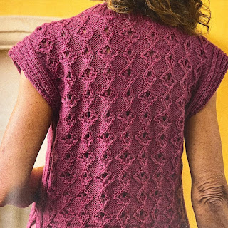 Model facing away from the camera to show the back of a hand knitted top