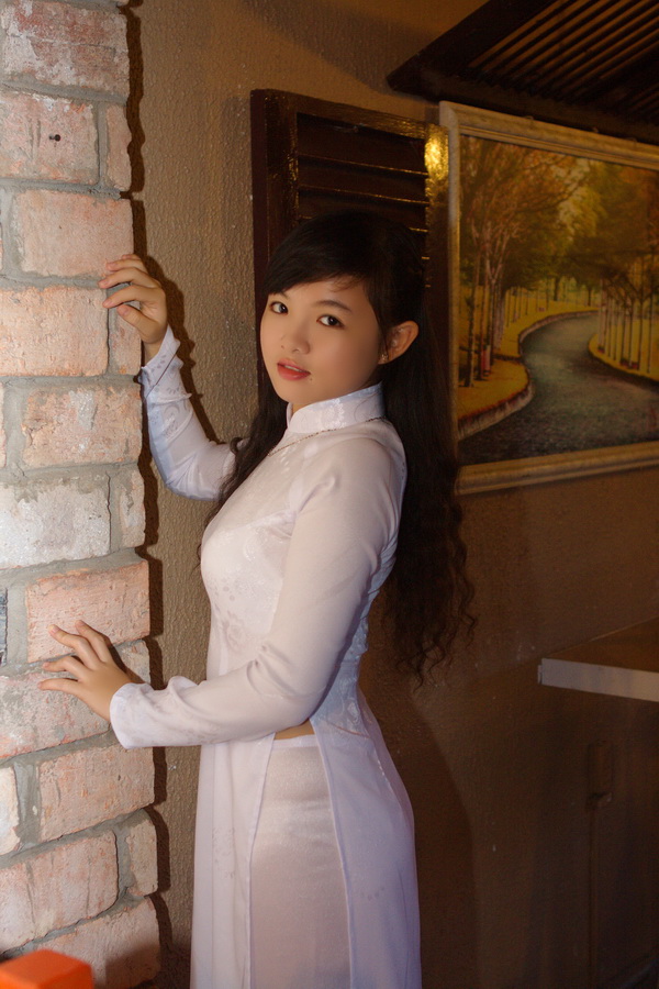 Thiếu nữ áo dài trắng đứng tay vịn tường