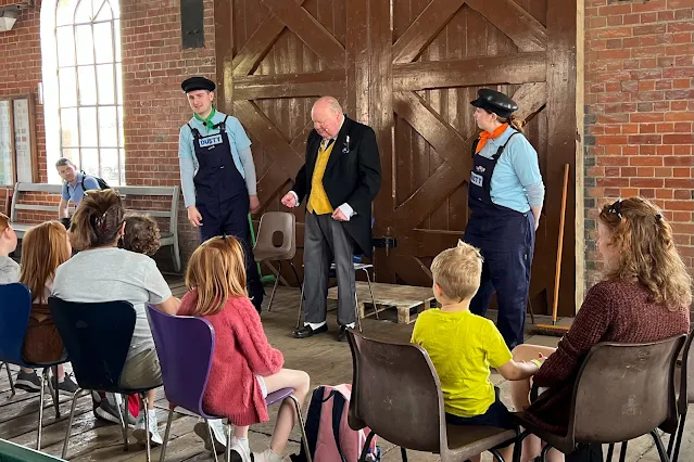 A group of children and adults in chairs watching Sir Topham Hatt, Rusty and Dusty at a Day Out With Thomas Event