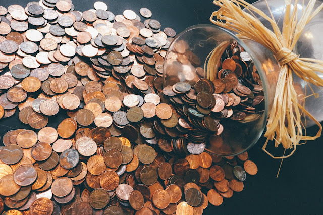 Spilled glass jar of pennies