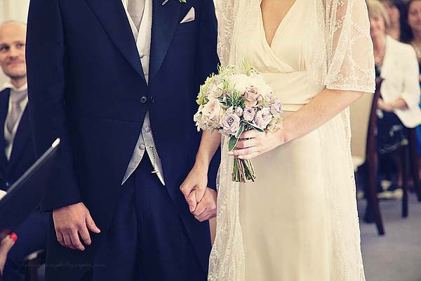 bride and groom holding hands during ceremony Marylebone Town Hall wedding