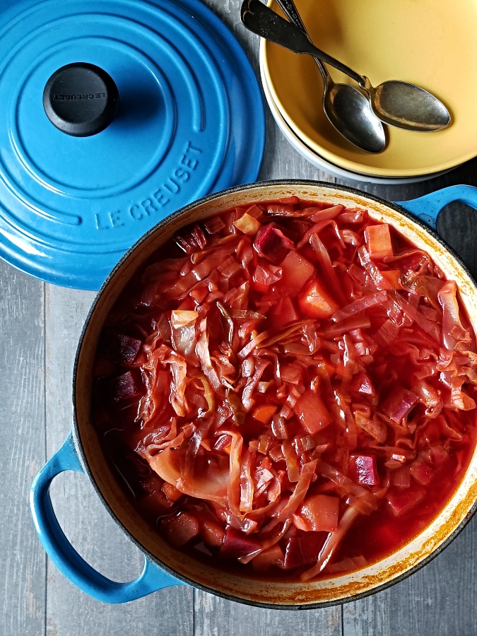 Vegetarian beet soup in a large pot with bowls