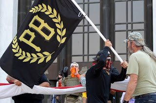 A suppoters Flying Flag of the Far Right Proud Boys' group in the Oregon State Capitol
