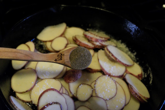 Pepper being added to the potatoes.