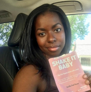 Camille Winbush clicking a selfie while showing a book sitting inside the car