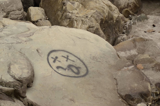 Closed eyes tongue out smiley drawn on rocks