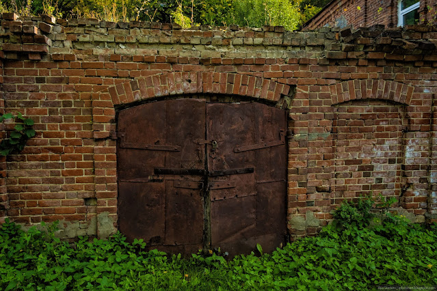 Массивные железные двери у старого кирпичного склада