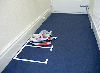 white markers on blue carpet, showing where shoes go