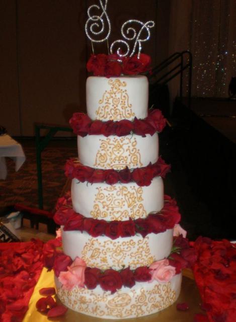 Five tiered wedding cake covered in a draped fondant with real red rose 