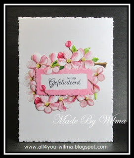 Een felicitatiekaartje met allemaal bloemen rondom een tekststempel. A birthday card with flowers all around a text stamp.