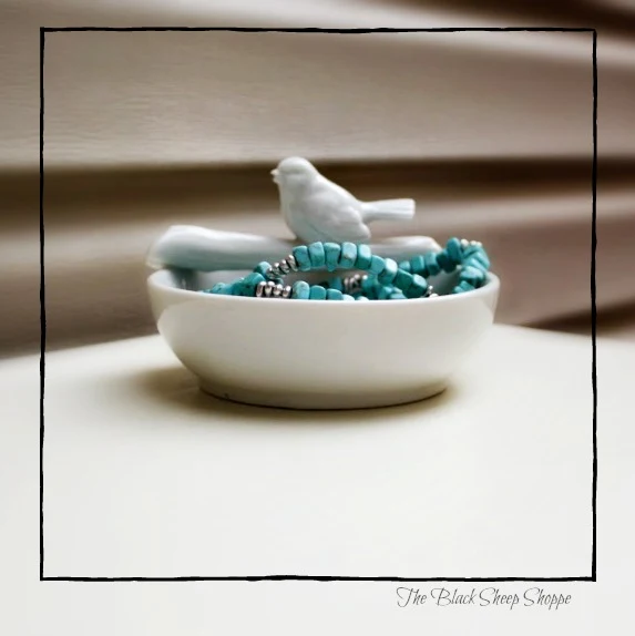 Jewelry in white ceramic dish.