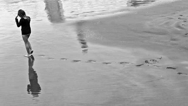 Joven caminando en la playa.B/W