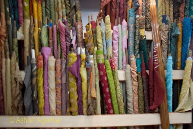 Bundles of pieces of cloth arranged at the side inside a shop in Amritsar