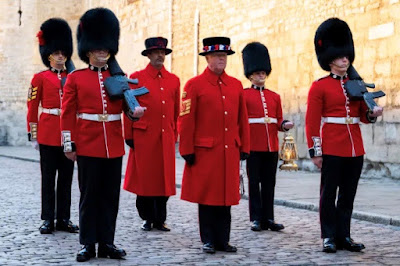 Phot shows 4 guardsmen, 2 carrying guns,  in bearskin hats flanking 2 beefeaters