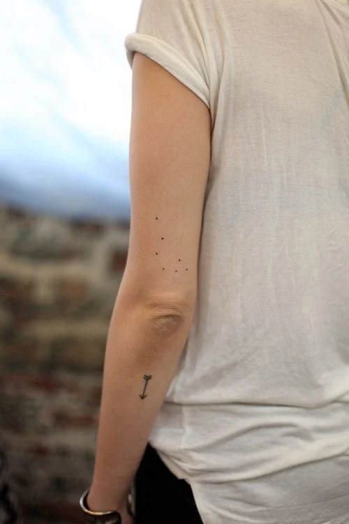 chica con tatuaje de la constelación de libra en el brazo posterior