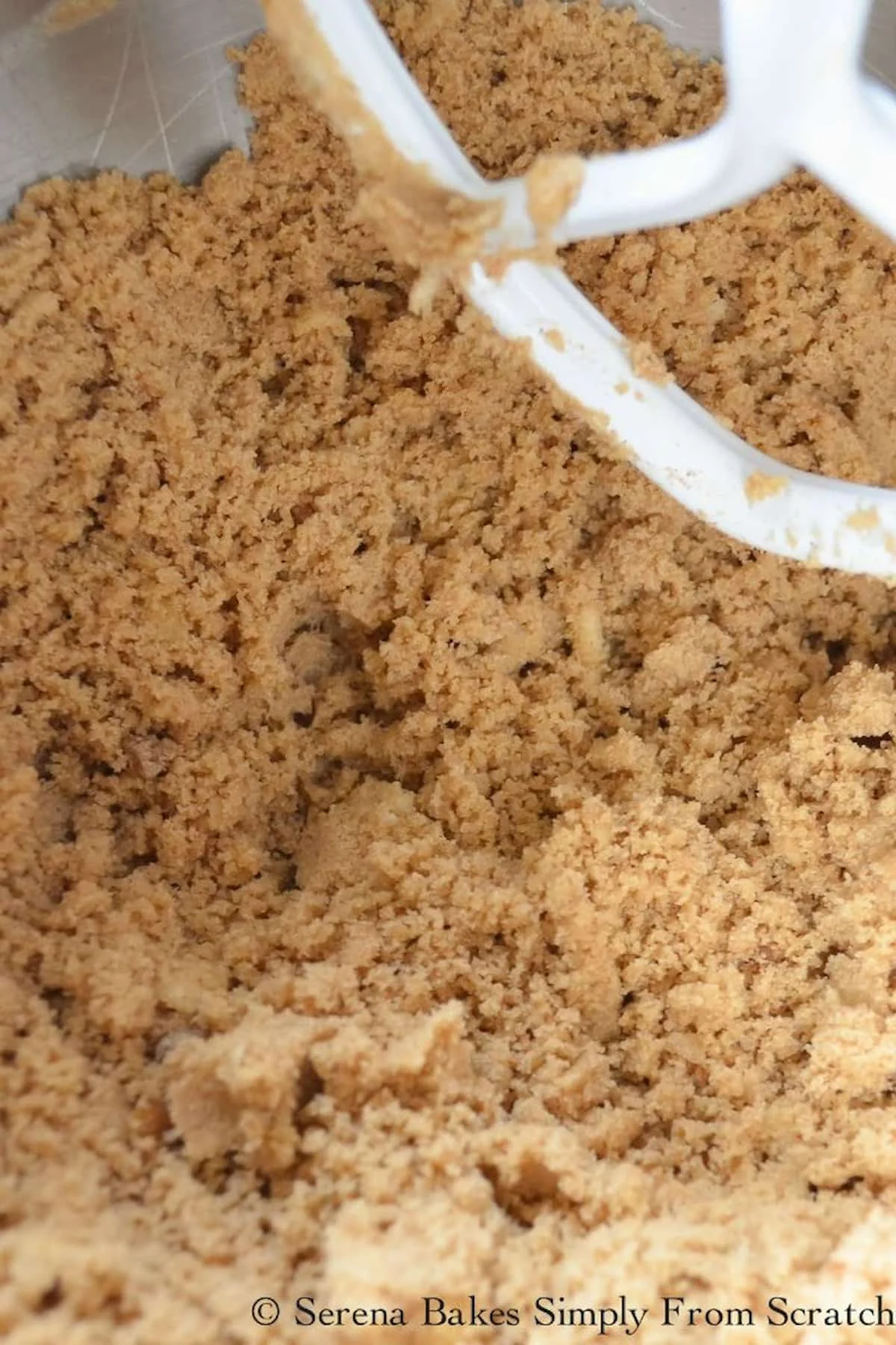 A down shot of Blueberry Cinnamon Crumb Coffee Cake crumble topping a swirl mixture in a mixing bowl.