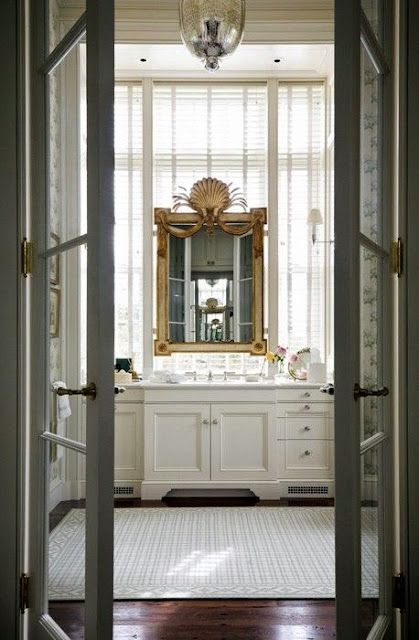 white master bathroom with dark hard wood floors gold framed gilt mirror