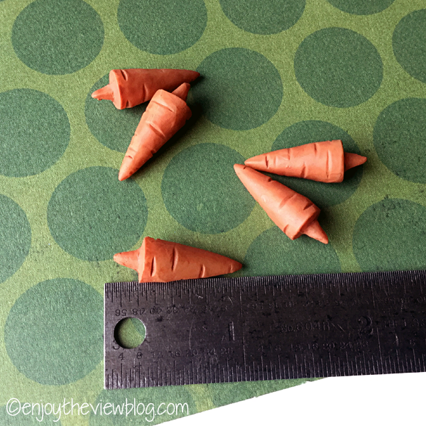 tiny carrot noses lying next to a ruler to show size