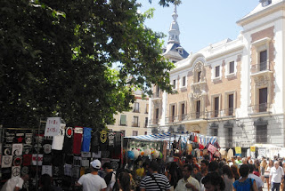 Numerosoas personas alrededor de los puestos de vendedores durante el mercado callejero de los domingos.