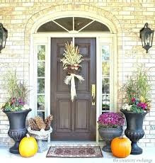 Fall floral display in urn by front door of home