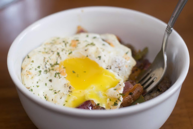 The sweet potato hash in a bowl, with the egg on top, and the yolk oozing out.  