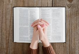 A woman praying with bible