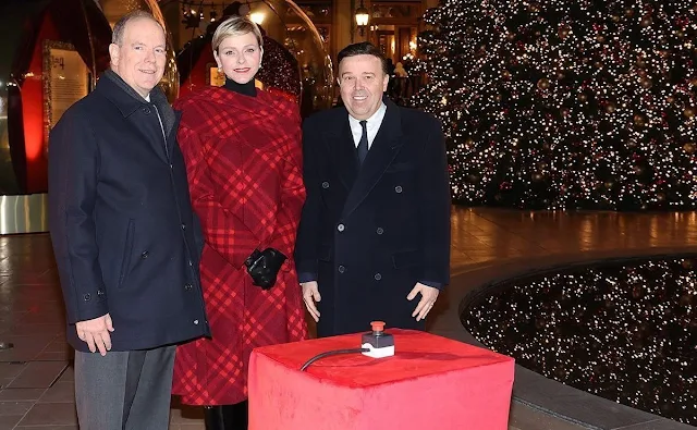 Princess Charlene wore a red ripple check draped coat by Burberry. Princess Stephanie and Melanie de Massy