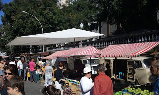 Barracas e pessoas transitando na feira