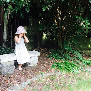 Girl in garden covering her eyes