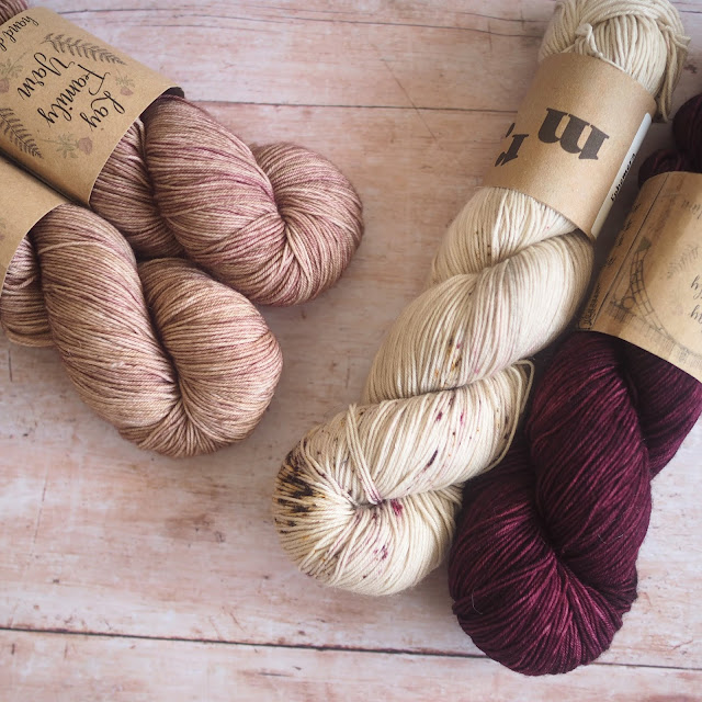 4 hanks of yarn including 2 coffee-coloured, 1 beige and 1 burgundy