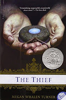 The cover of the book, The Thief shows an amulet in a pair of hands