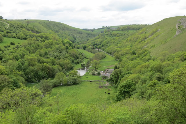 The river winding through farmland and the steep sides of the dale.