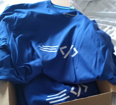 Bok of blue t-shirts with the Rapid XAML logo