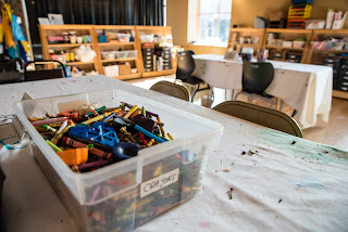 a plastic tub of crayons sits atop a table at the Museum of Visual Materials in Sioux Falls South Dakota