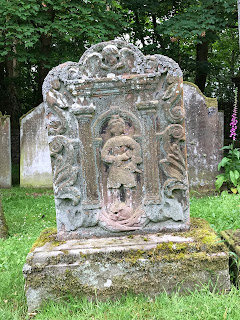 A photo of an ornate gravestone in Durisdeer Churchyard with a figure carved on it.  Photograph taken by Kevin Nosferatu for the Skulferatu Project.