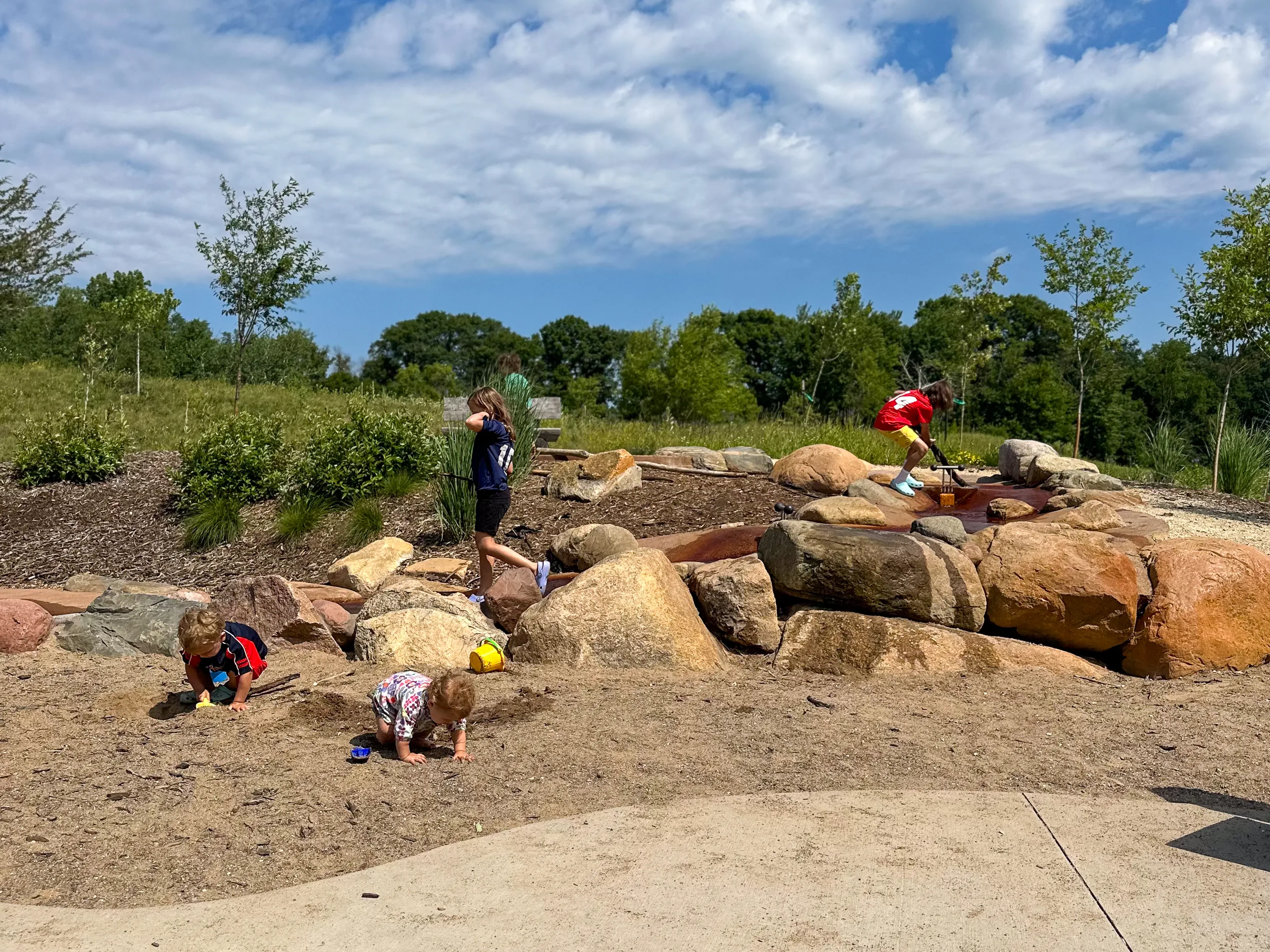 Children play at a nature playground and explore the benefits of outdoor play