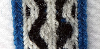 A section of tablet woven band with the weft passing over a thread it should be under