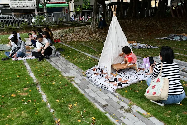 ▲親子在舊鐵路宿舍廣場上或搭小帳篷或席地野餐。（彰化市公所提供）