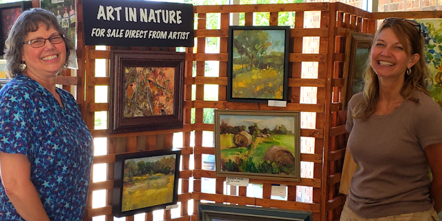 Artists Carol Foster and Lisa Riedl at Crabtree Nature Center's art display.