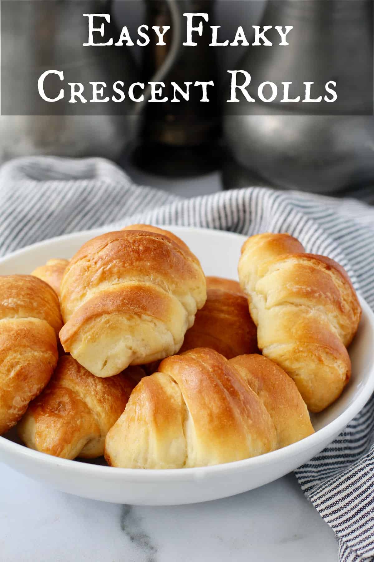 Flaky Buttery Crescent Rolls in a white ceramic bowl.